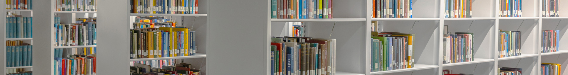 White shelves full of books at a library.